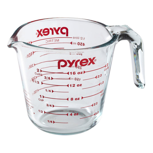 Pyrex measuring cup with red measurement markings on a white background